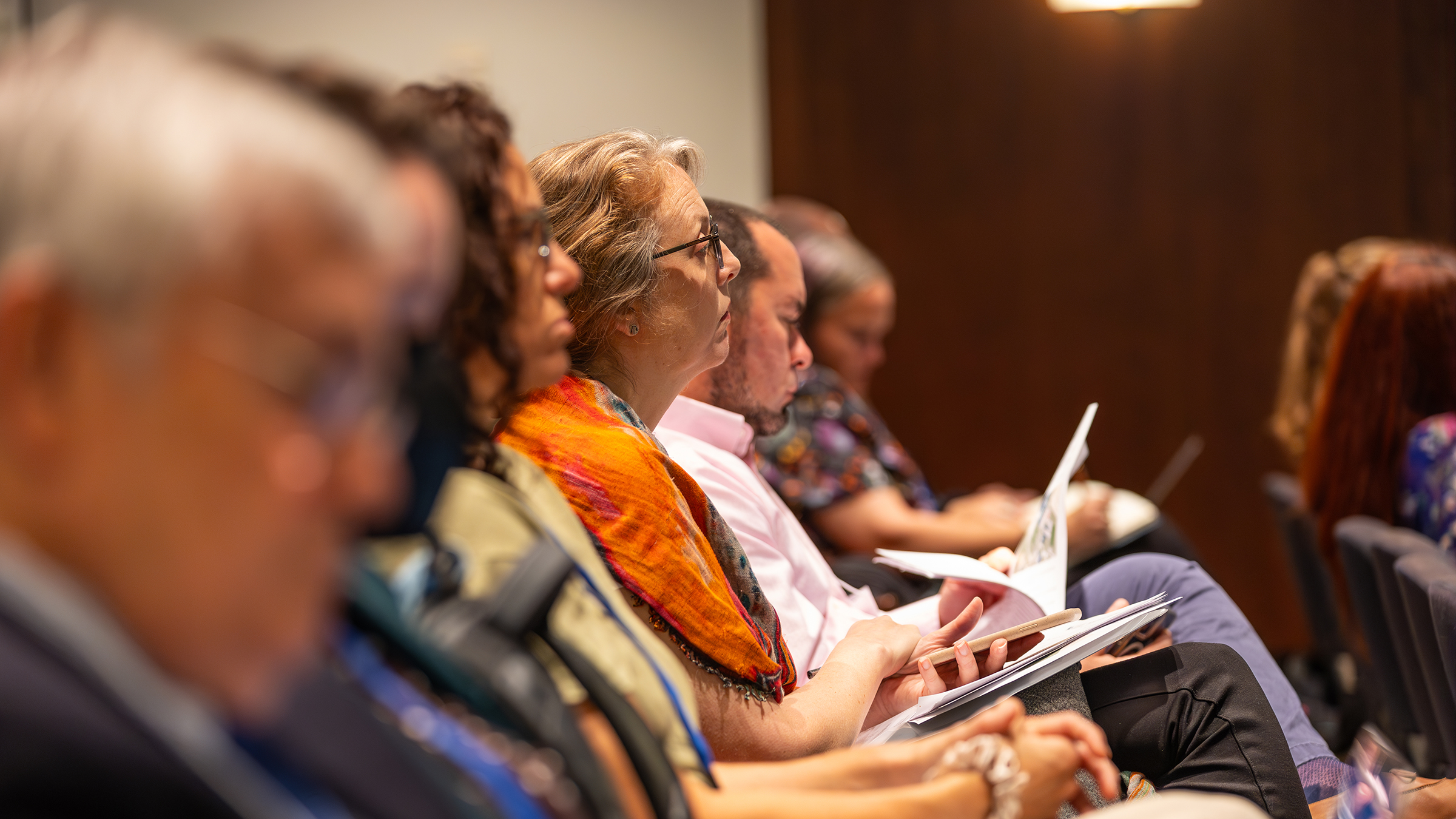 Audience members listen to a speaker