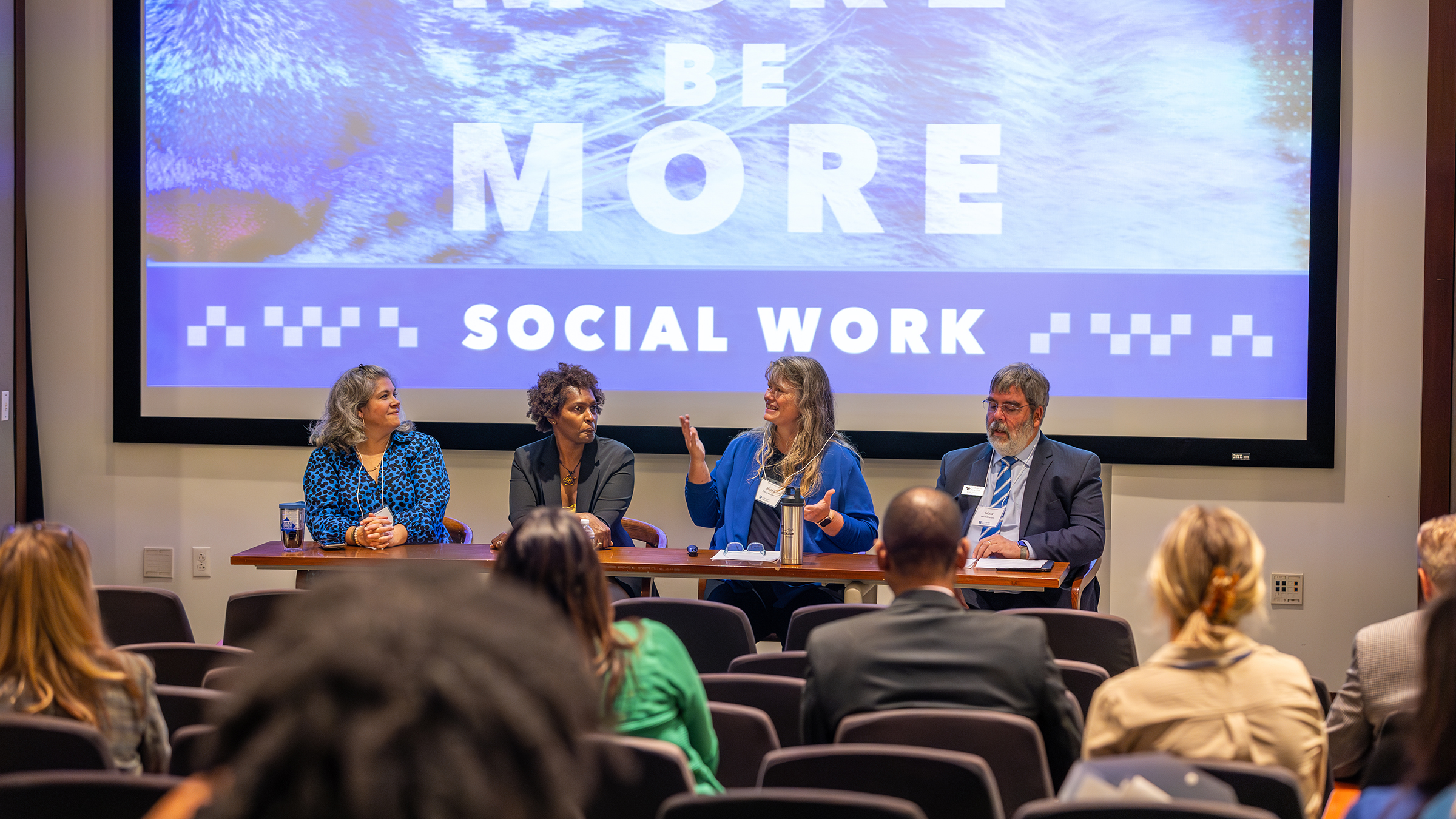 A panel speaks in front of a crowd