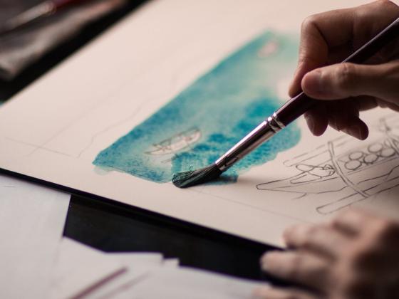 Image of a person painting a watercolor landscape
